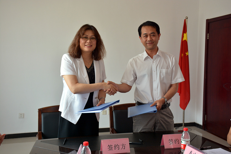 王淑梅与王建超代表双方签署协议并为工程实