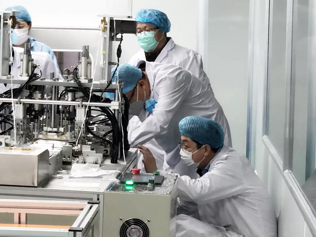 沈阳大学机械工程学院焊接系主任路林副教授(弯腰调试者即为路林)为沈阳浩宁实业有限公司紧急调试和维修口罩耳带超声波生产线